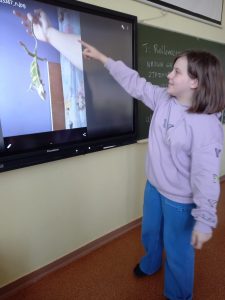 dziewczynka przed tablicą multimedialną