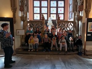 uczniowie z przwodniczką na schodach w historycznej sali ratusza