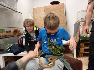 uczeń z wężem na kolanach